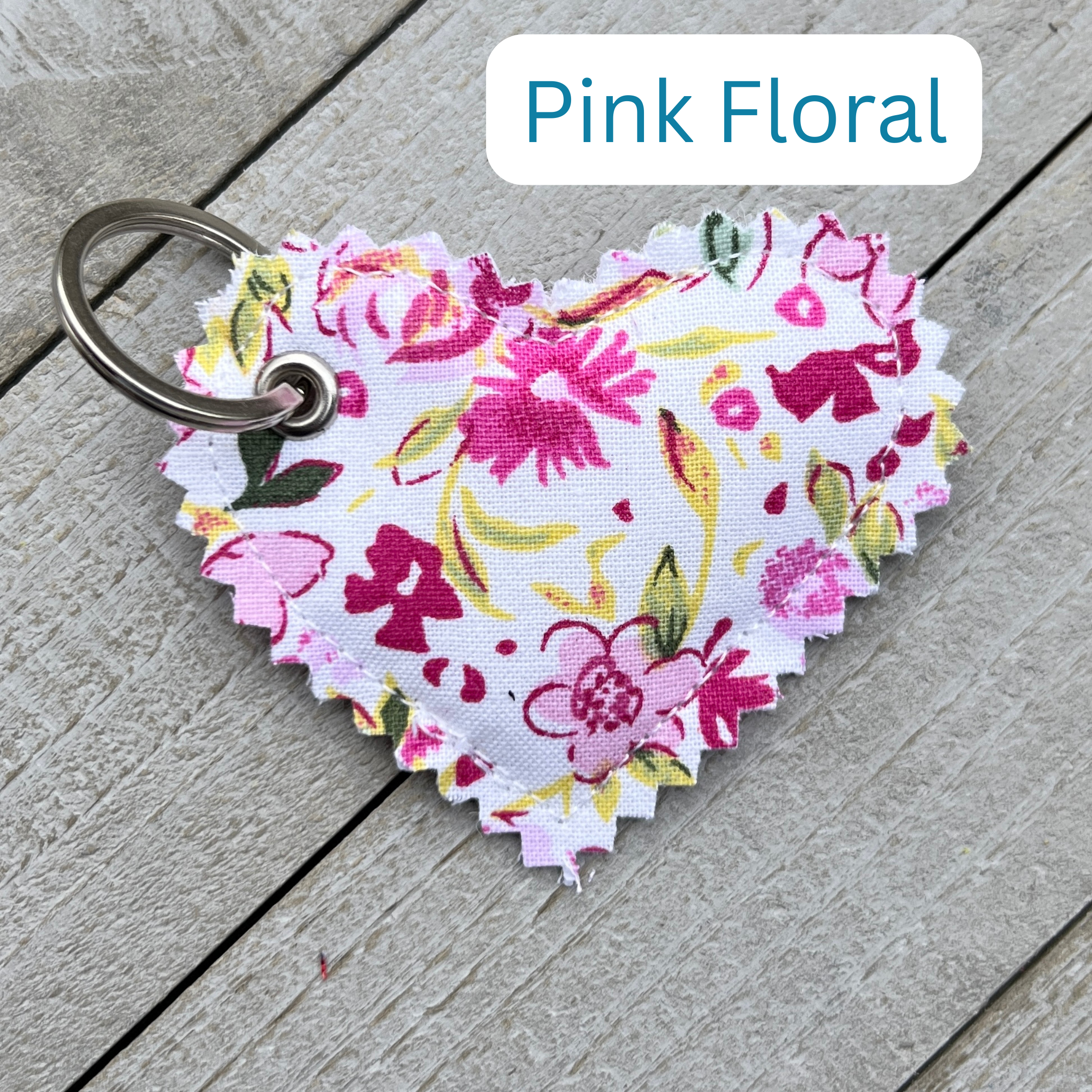 Heart-shaped pink floral keychain on a wooden surface with 'Pink Floral' text above.