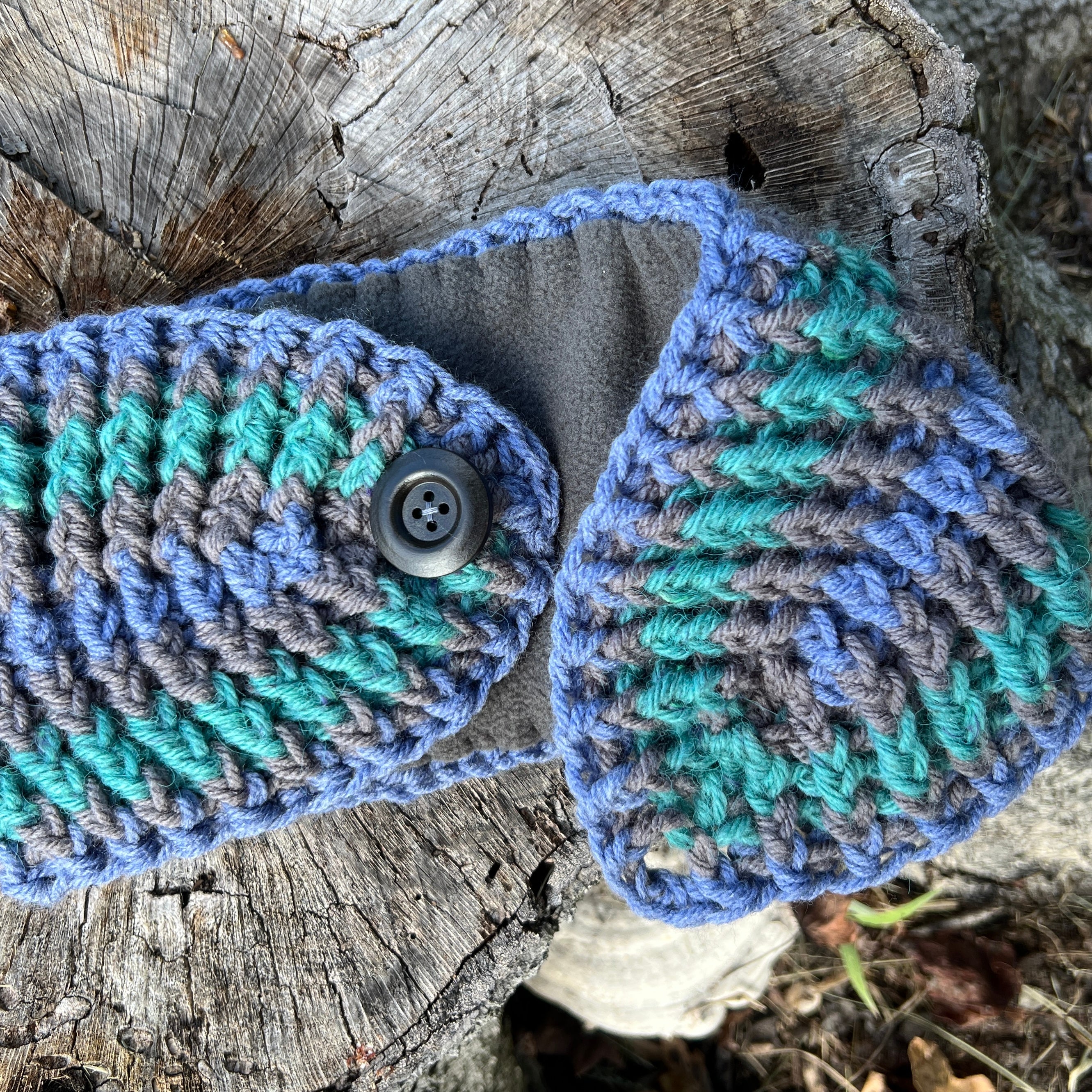 blue and gray striped ear warmer with open button