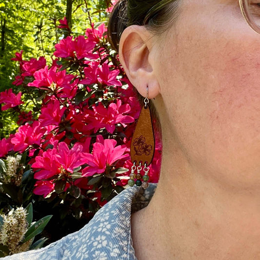 Person wearing earrings with a floral background