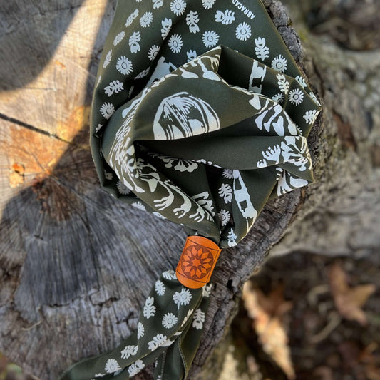 leather bandana slide on Folded green fabric with white patterns on a wooden surface