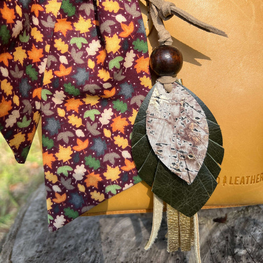 Decorative leaf-shaped ornament with a wooden bead on a fabric background