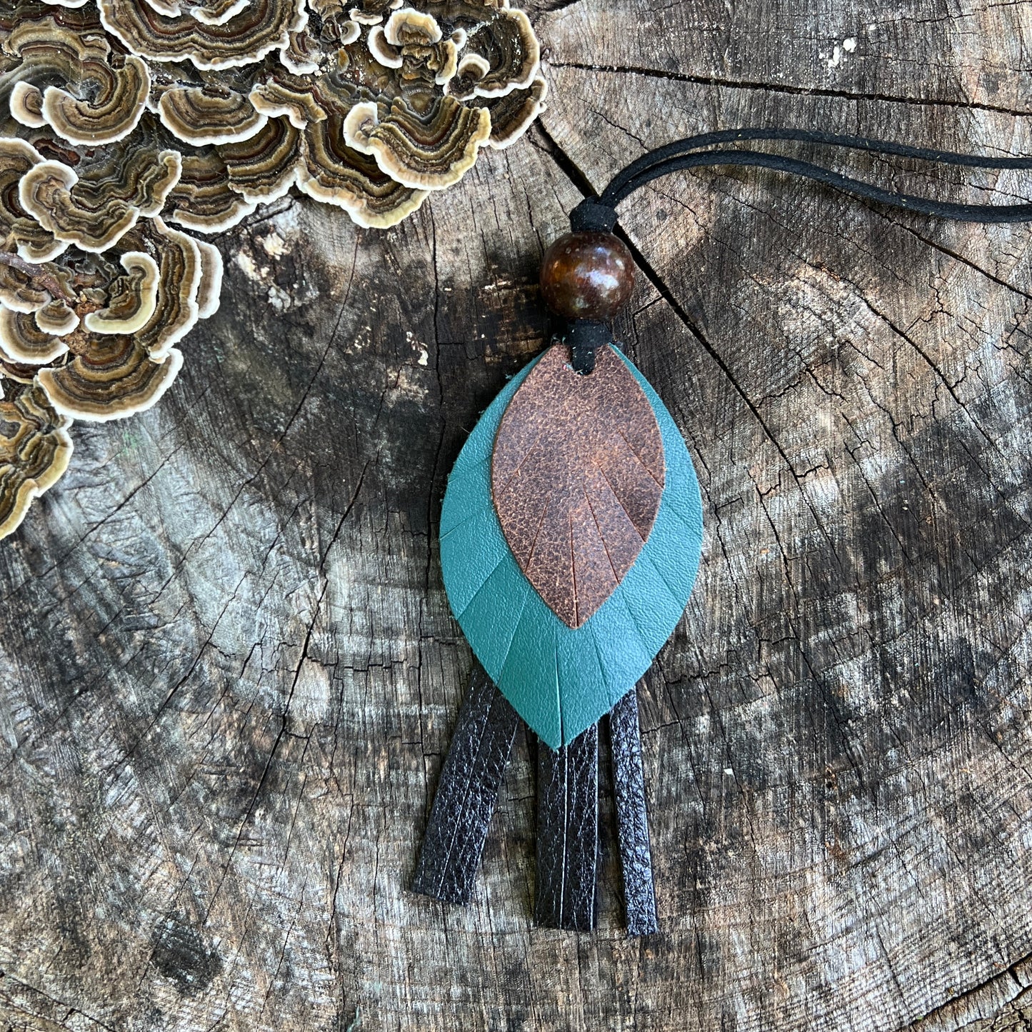leather feather on black leather tassel with wooden beads