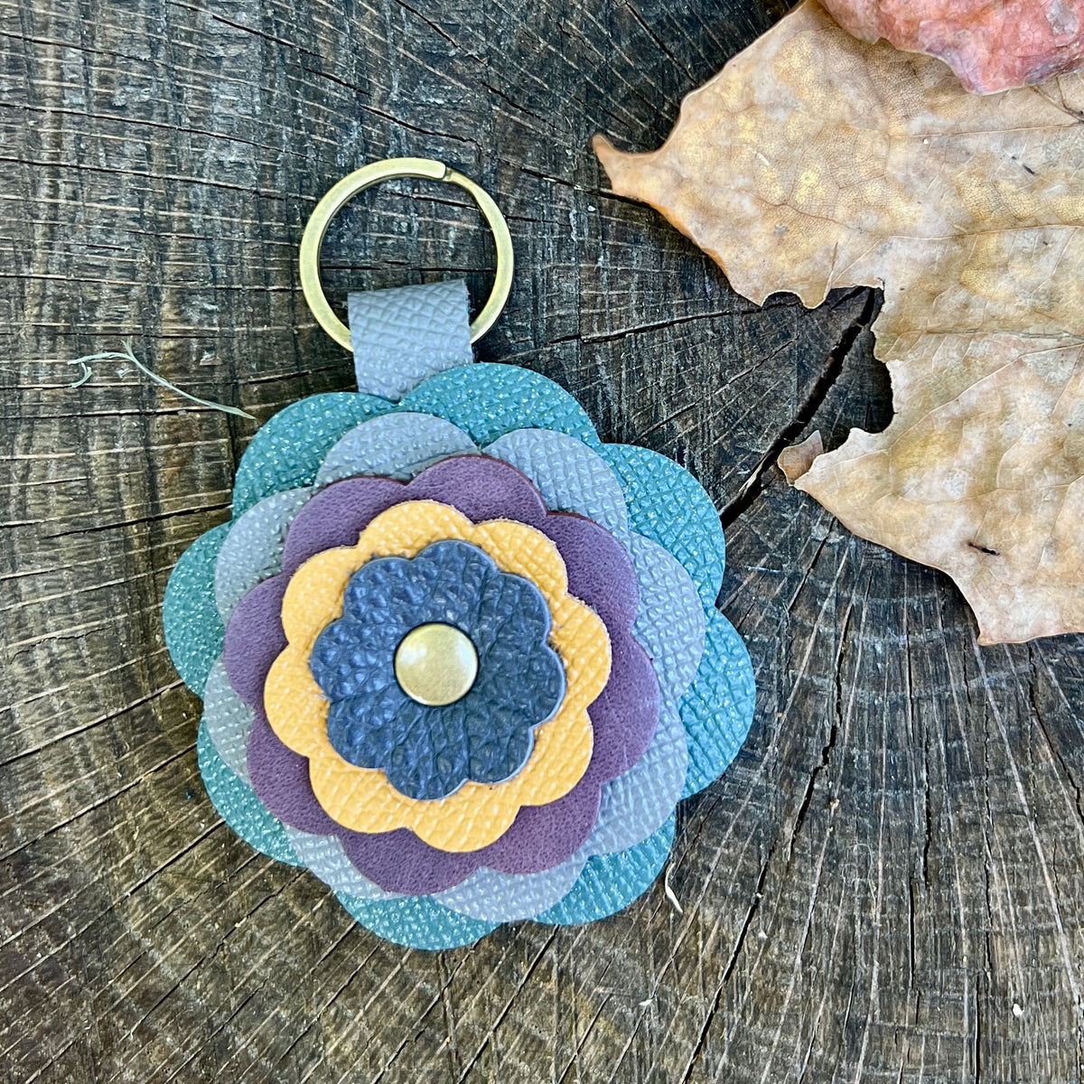 leather flower bag charm in shades of blue, purple and yellow