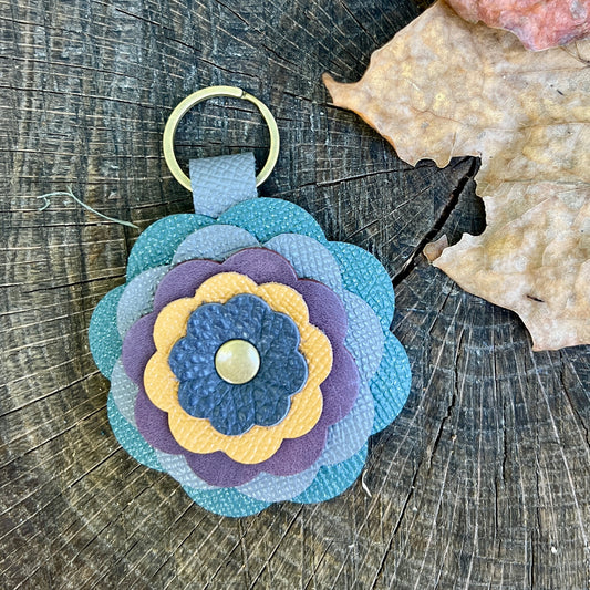 leather flower bag charm in shades of blue, purple and yellow