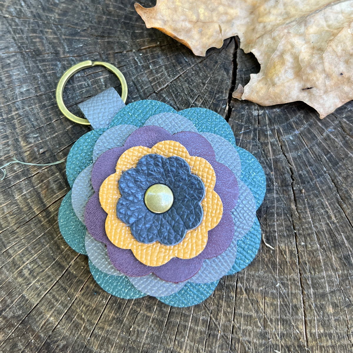 leather flower bag charm in shades of blue, purple and yellow
