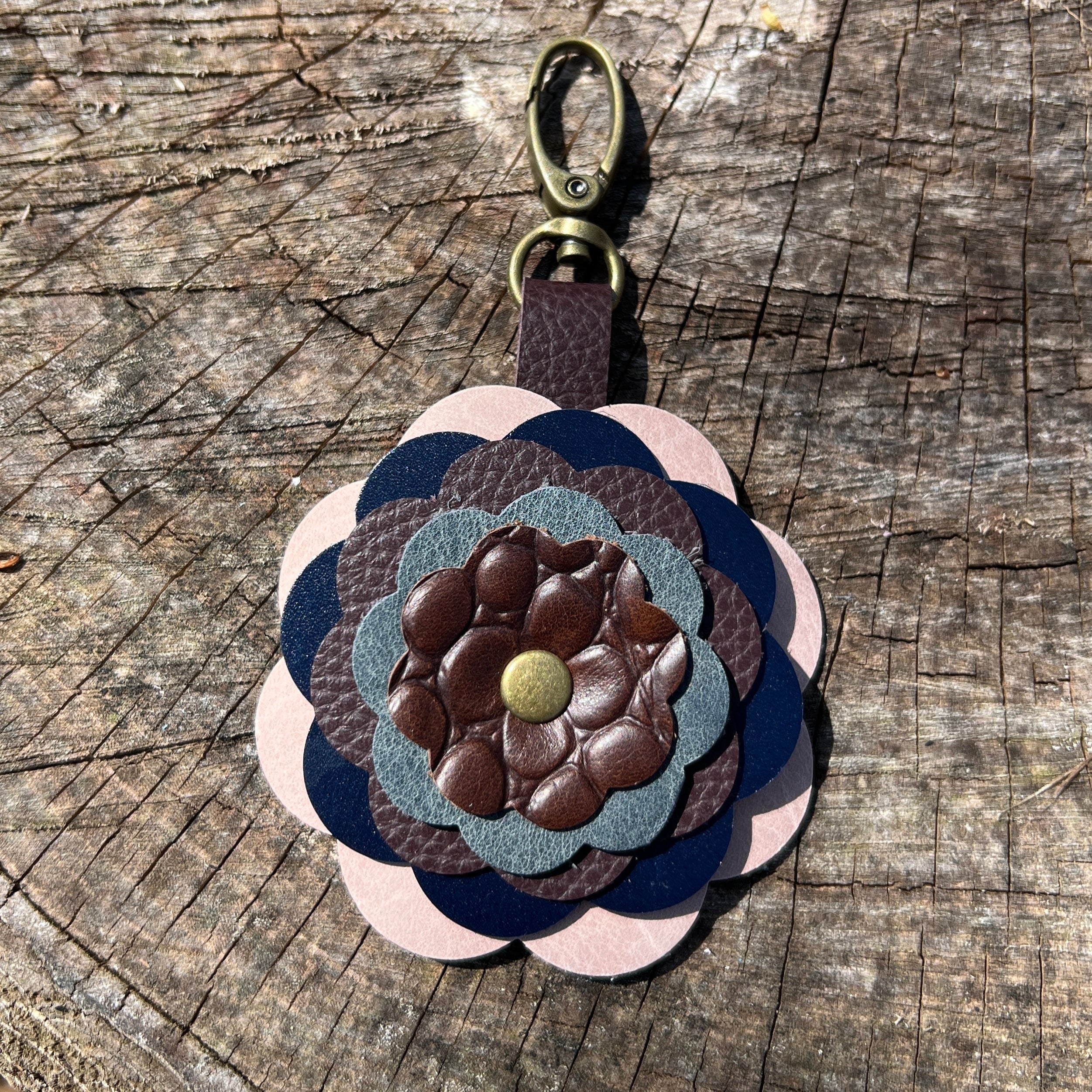 Multicolored leather keychain with a flower design on a wooden surface