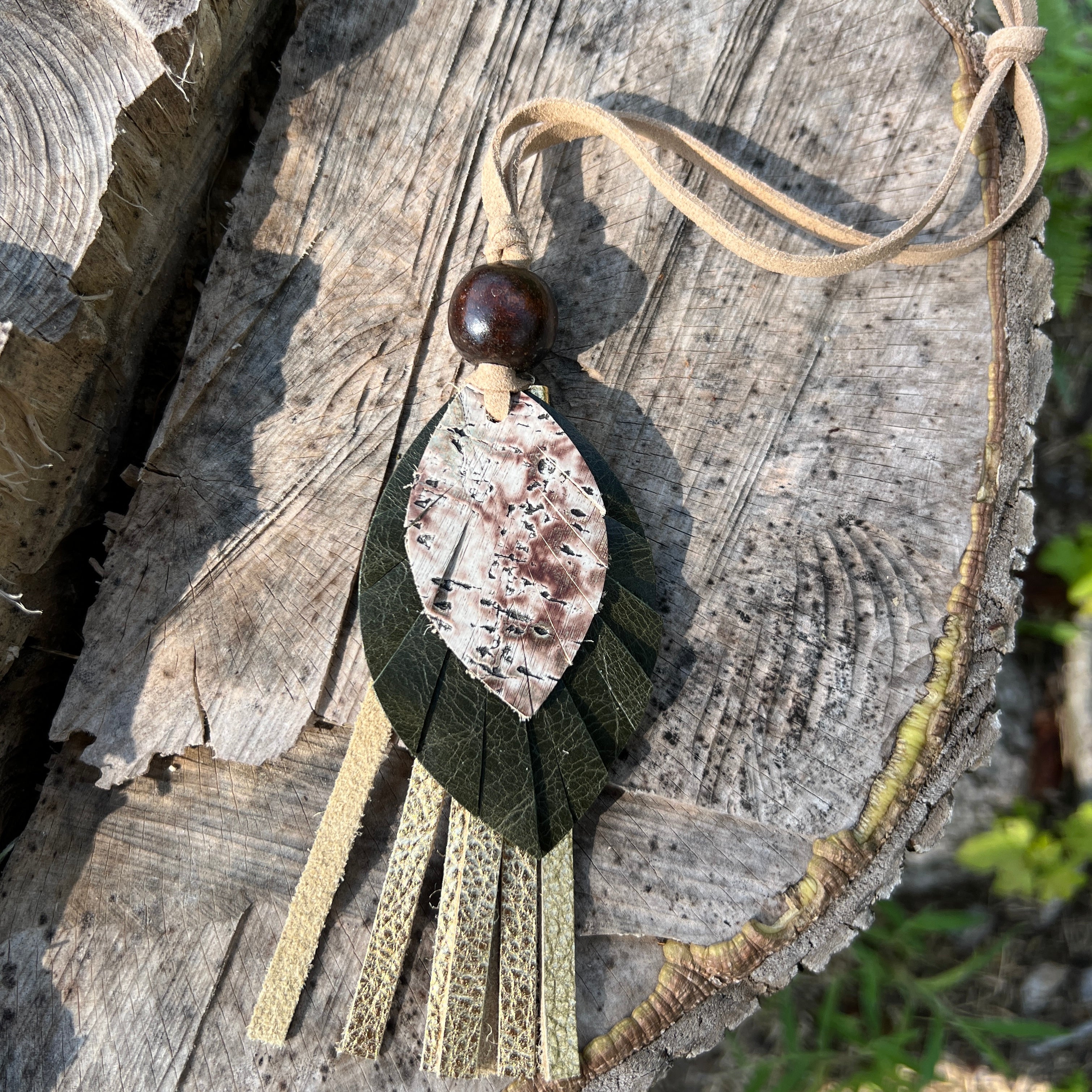 Decorative leaf and tassel purse charm on a wooden surface