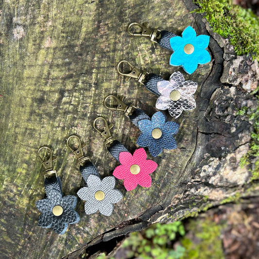 Colorful flower-shaped keychains on a wooden surface