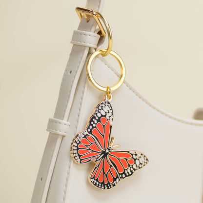 Butterfly-shaped keychain attached to a strap on a light background