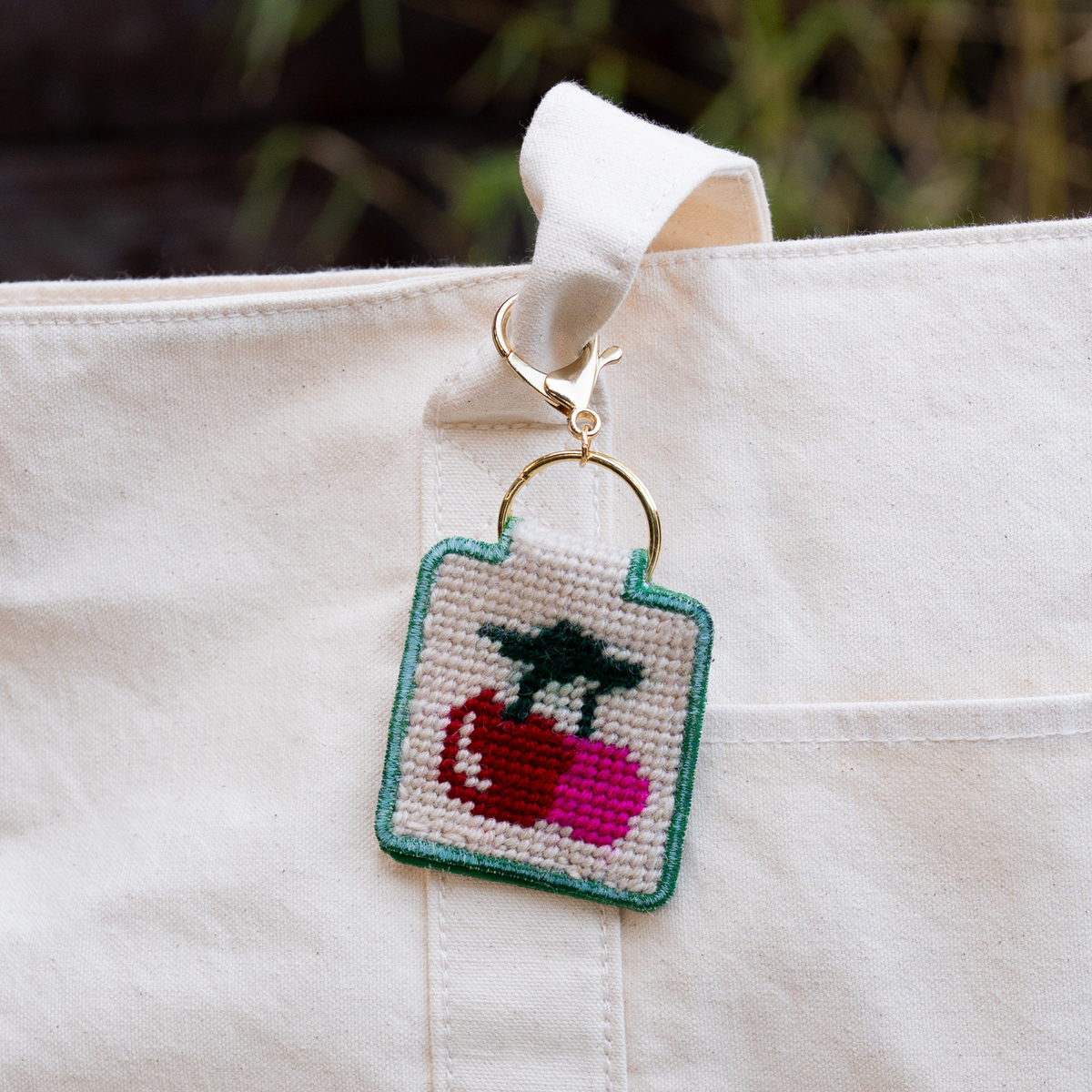 needlepoint keychain kit with cherry on white tote