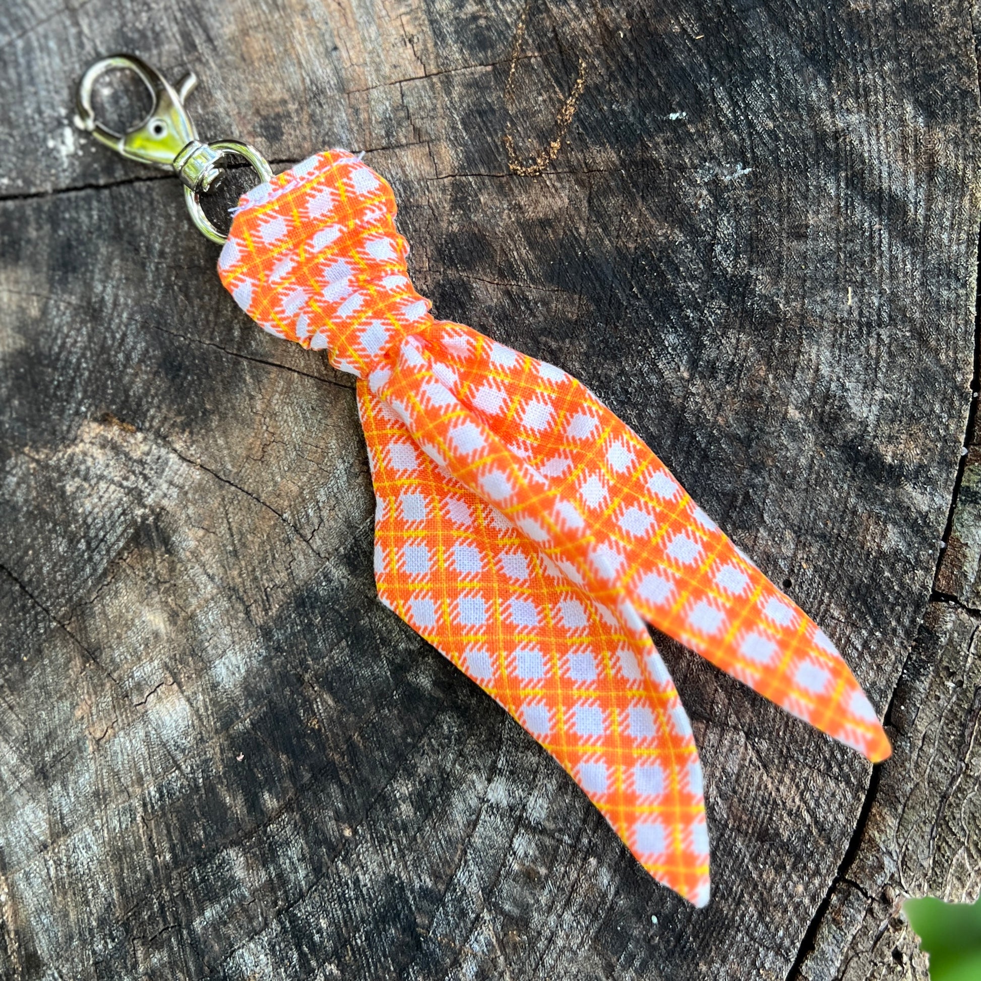 orange plaid mini scarf keychain on wood surface