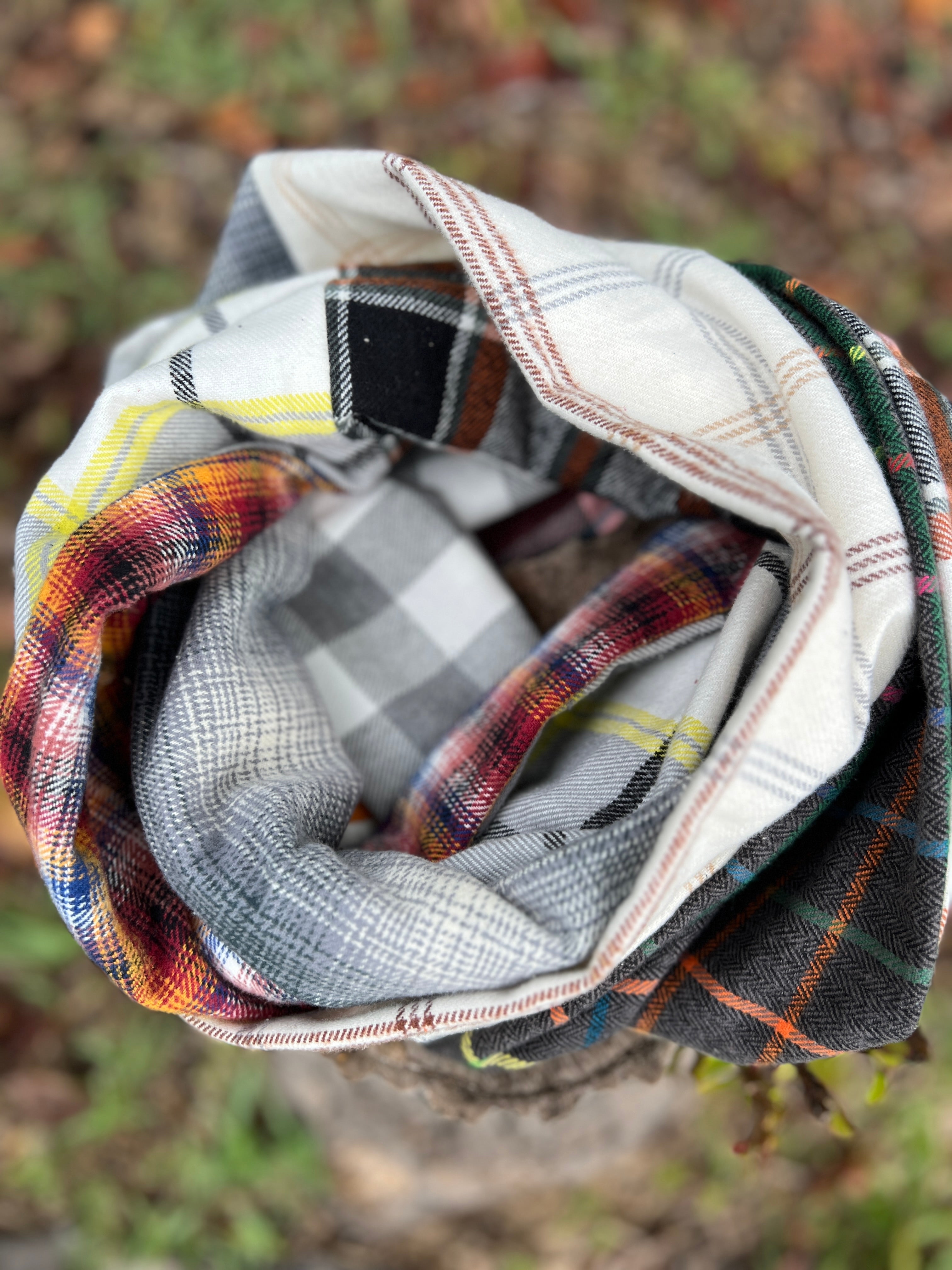 Rolled-up plaid fabric with a checkered pattern on a blurred natural background