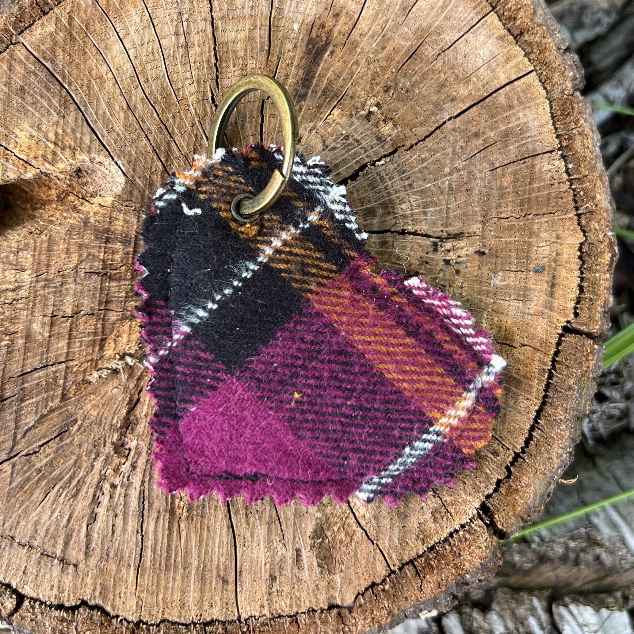 Plaid keychain on a wooden log