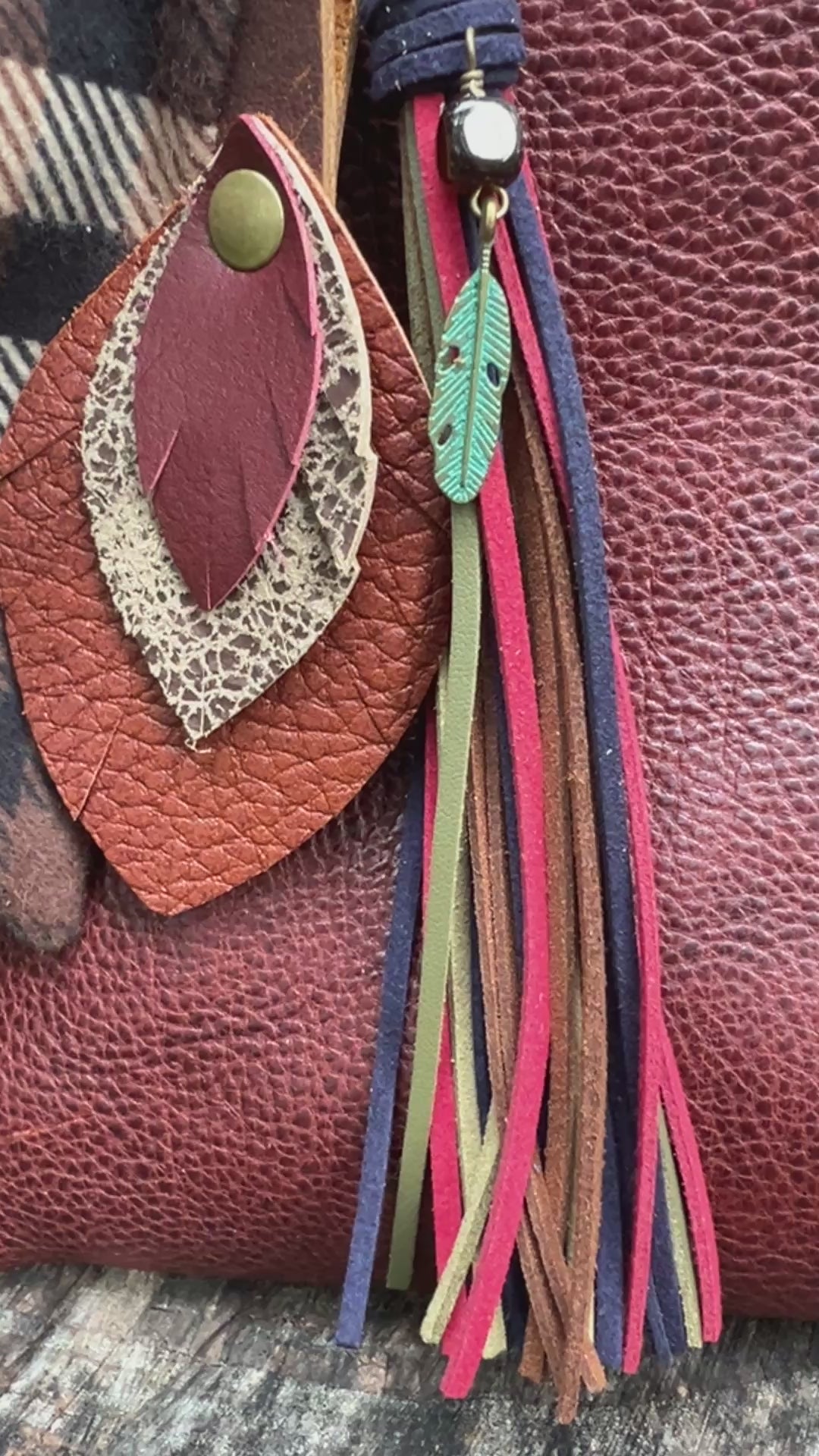 brown and deep red leather feather bag charm with tassel and flannel scarf on brown tote