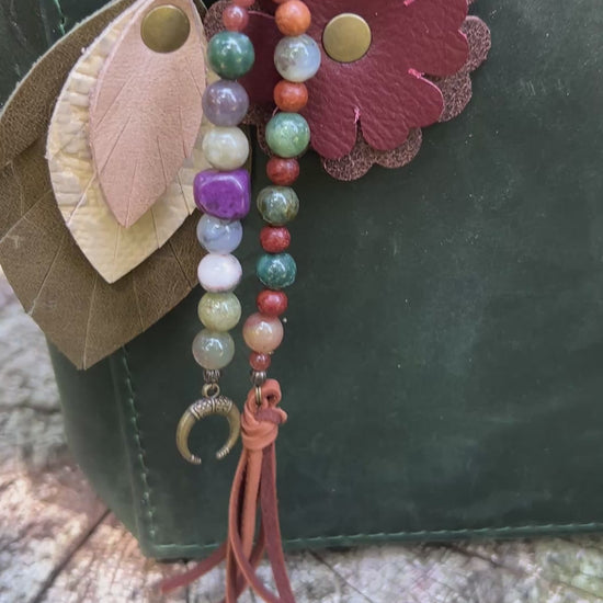 boho beaded bag charm with leather flower and feather on green tote