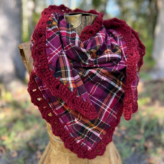 Flannel scarf in berry purple plaid with crochet trim draped on a mannequin outdoors, perfect for boho style.