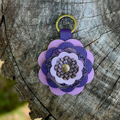 Purple leather flower bag charm on a wooden surface