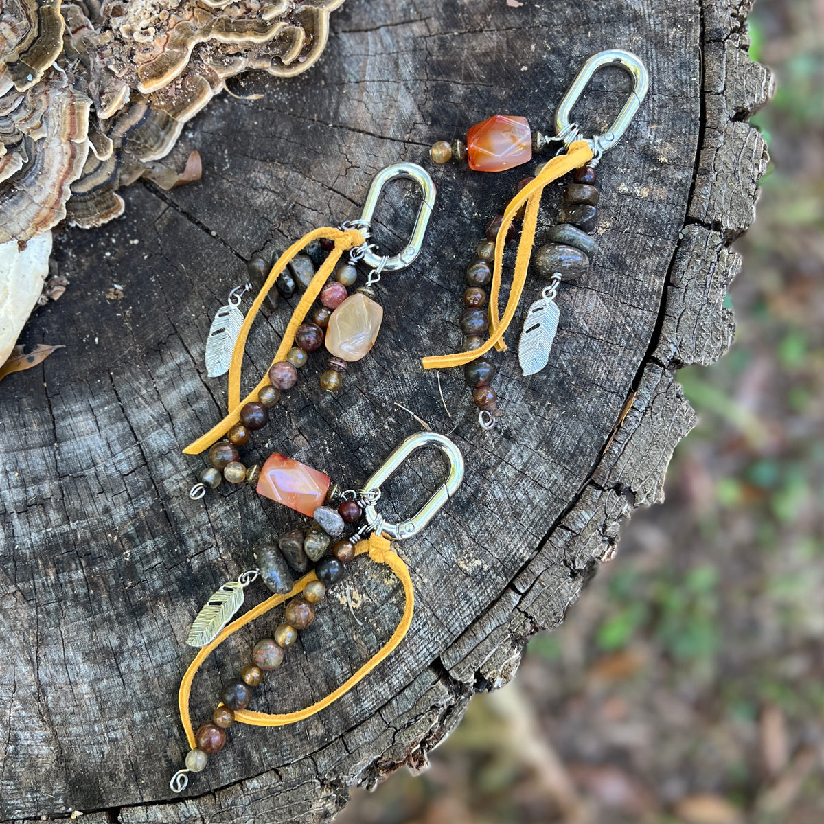purse charm with yellow tassel and natural stone beads on wooden surface