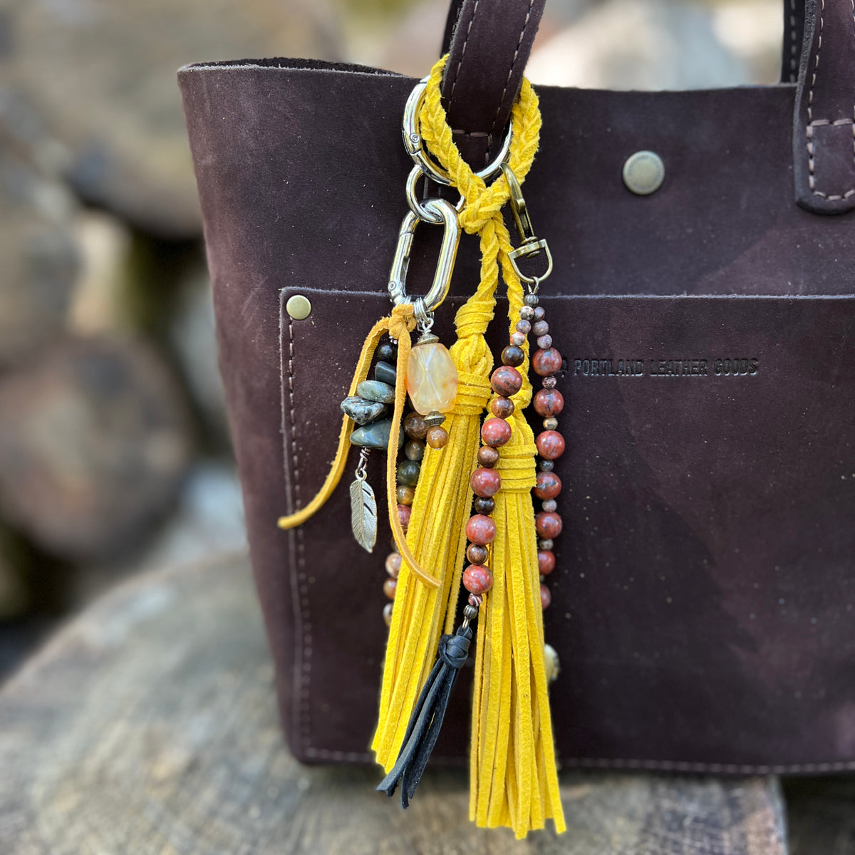 purse charm with yellow tassel and natural stone beads, yellow tassel and beaded charm with red stones on brown tote