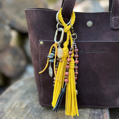purse charm with yellow tassel and natural stone beads, yellow tassel and beaded charm with red stones on brown tote