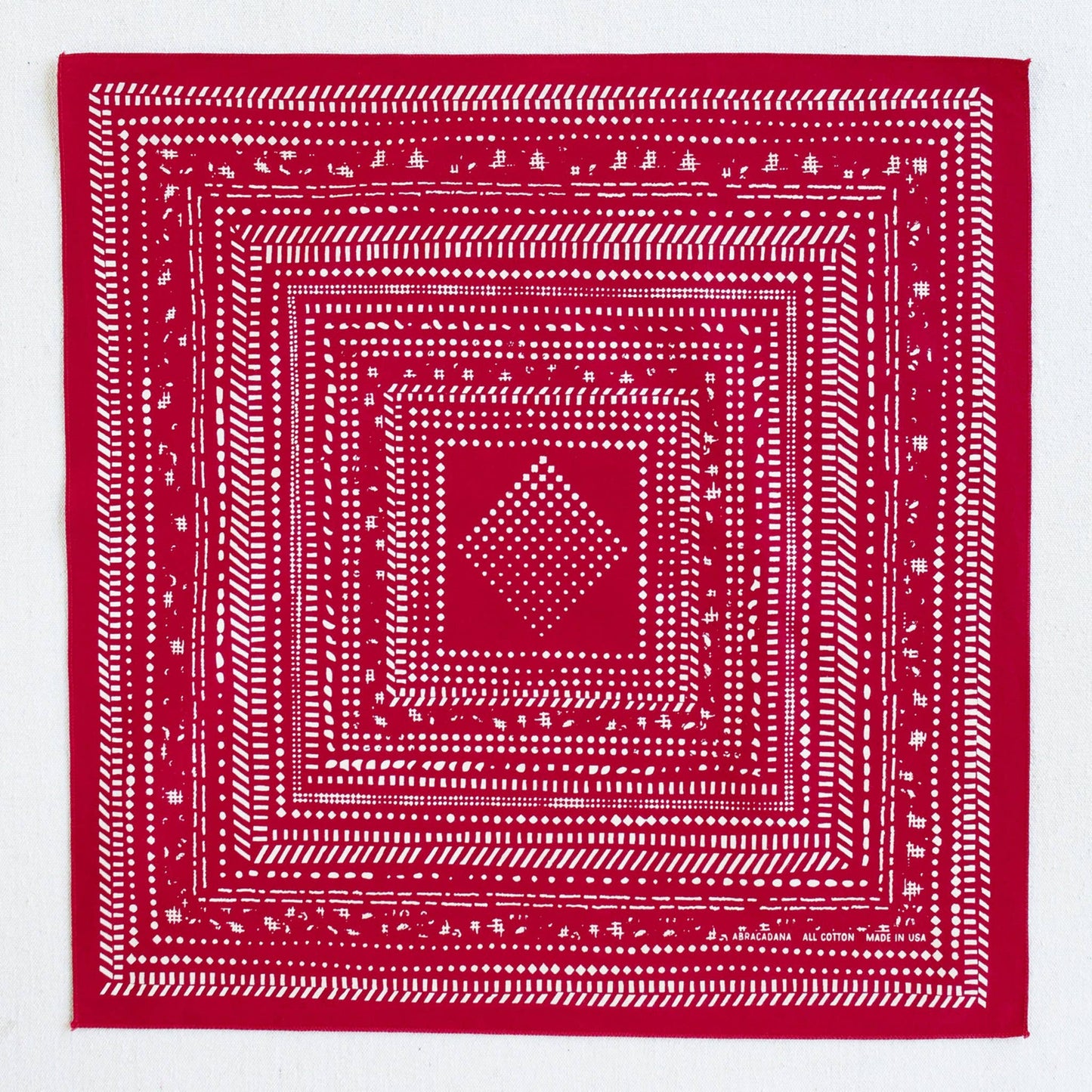 Red bandana with white geometric pattern on a white background