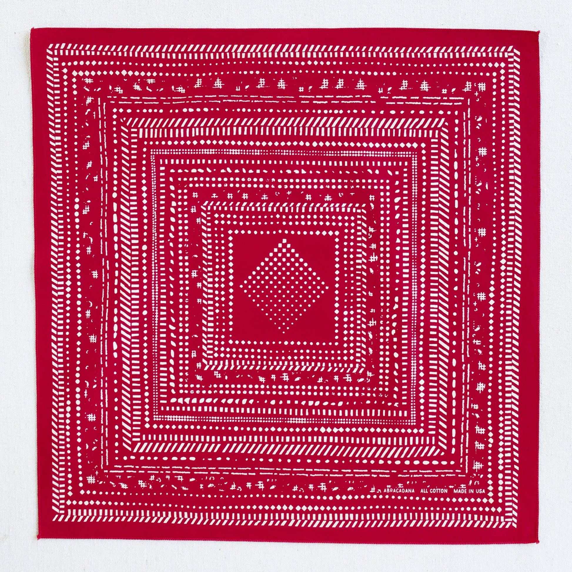 Red bandana with white geometric pattern on a white background