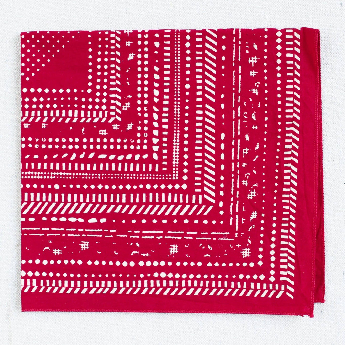 Red bandana with white pattern on a white background