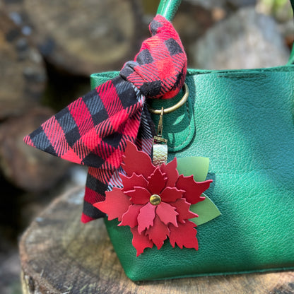 red flower bag charm with plaid scarf on green purse