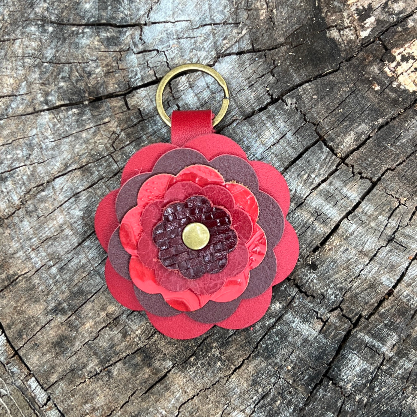 Red flower-shaped keychain on a wooden surface