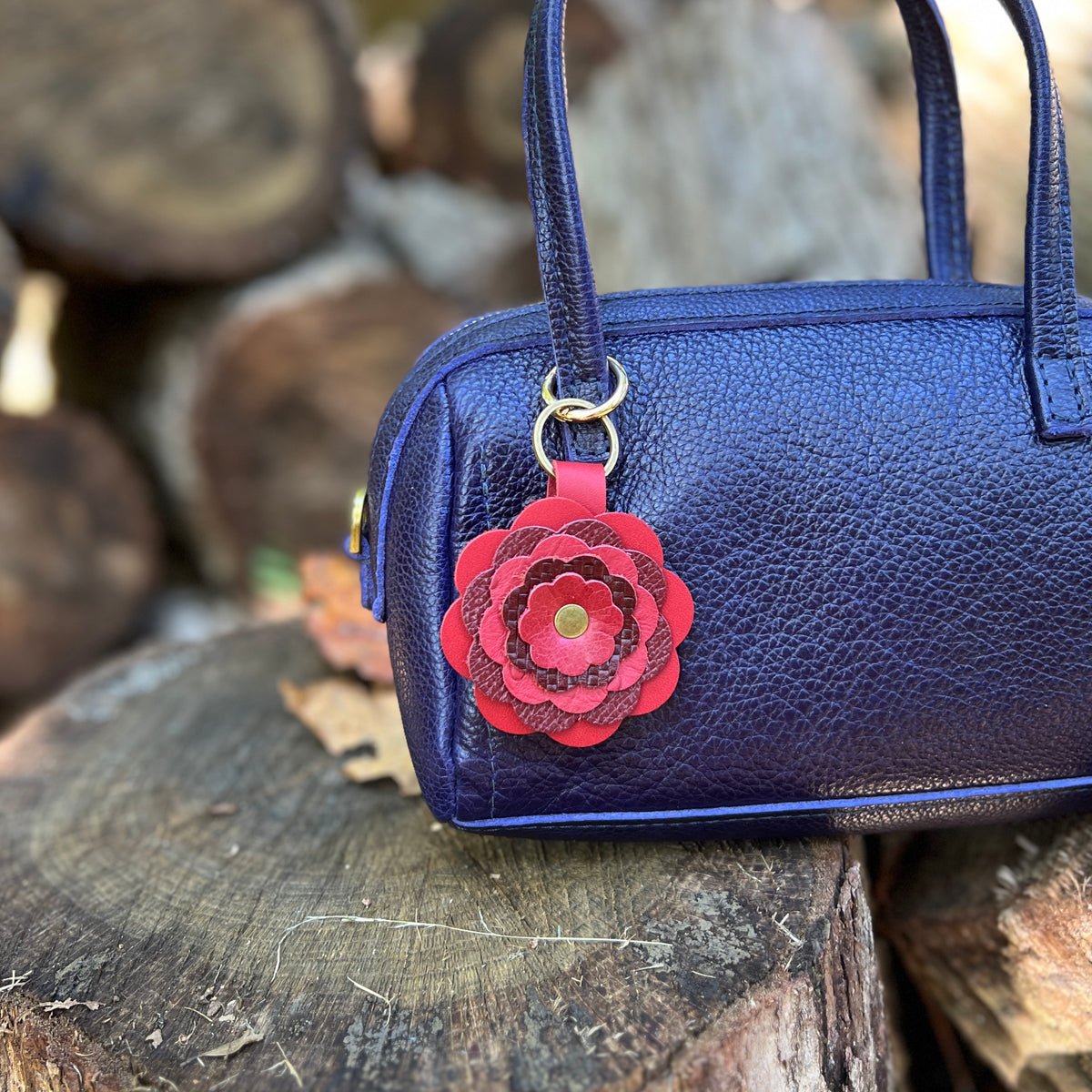 red leather flower purse charm on blue bag