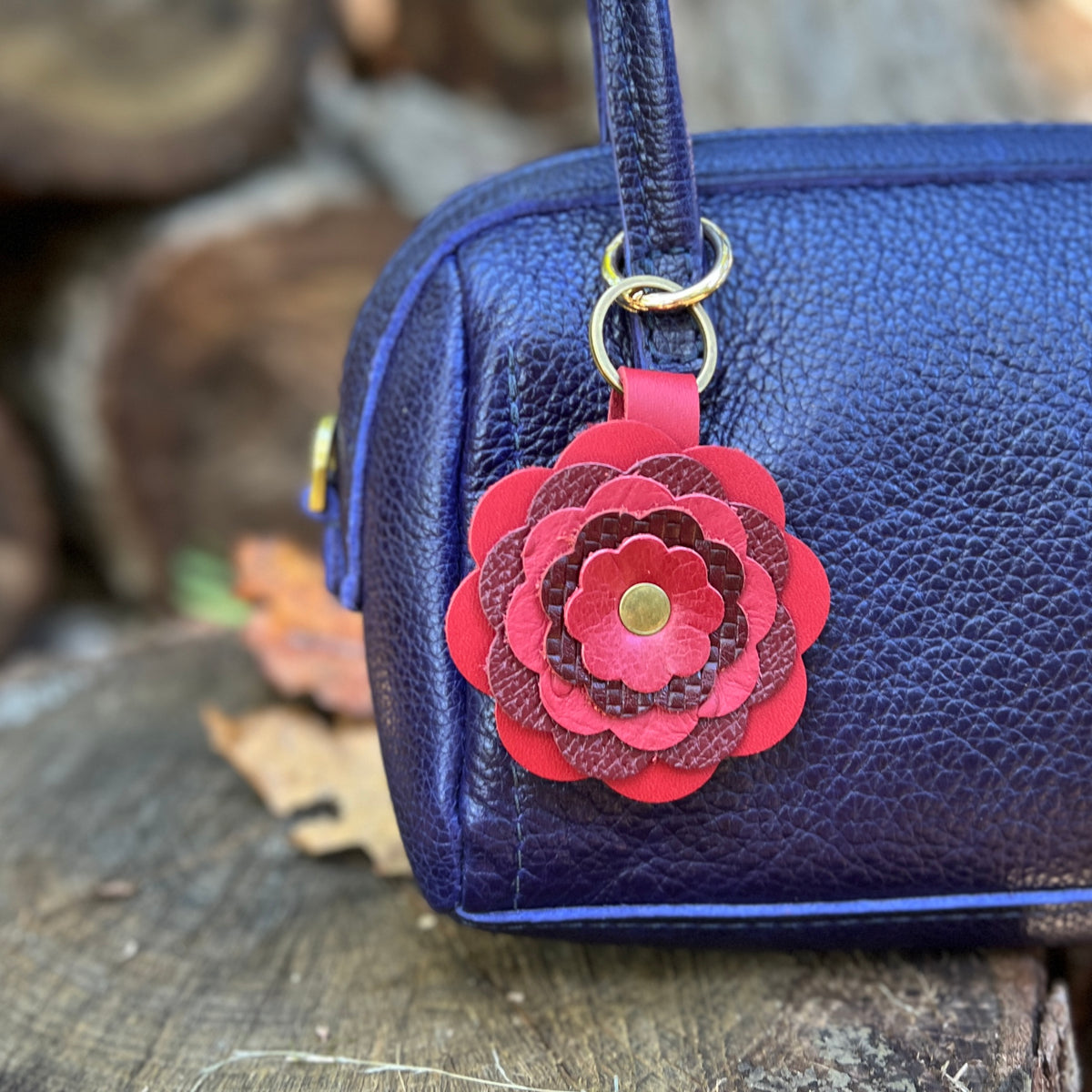 red leather flower purse charm on blue bag