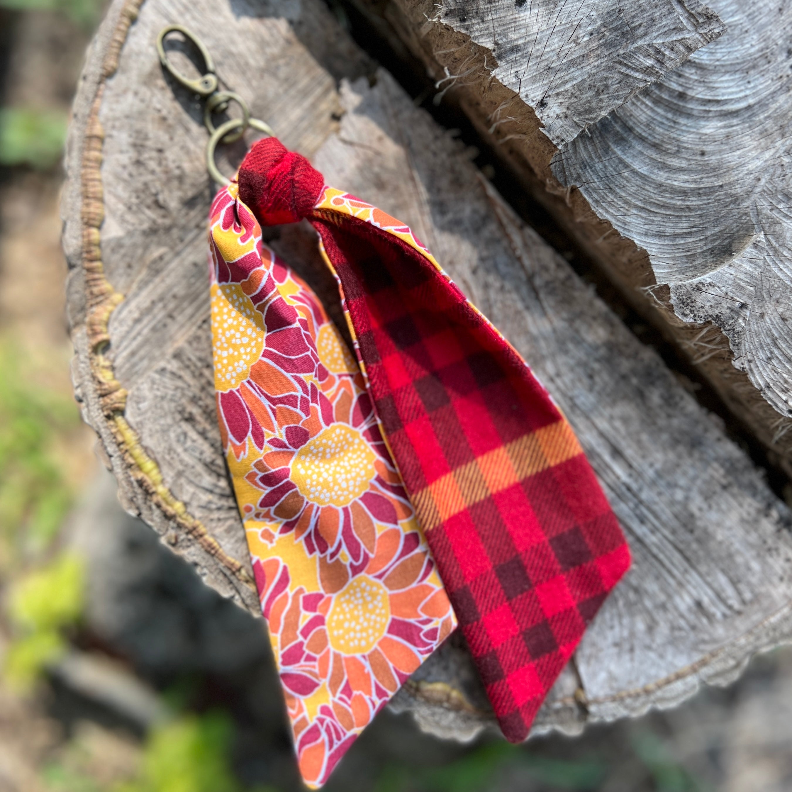 Keychain with floral and plaid designs hanging on a wooden surface