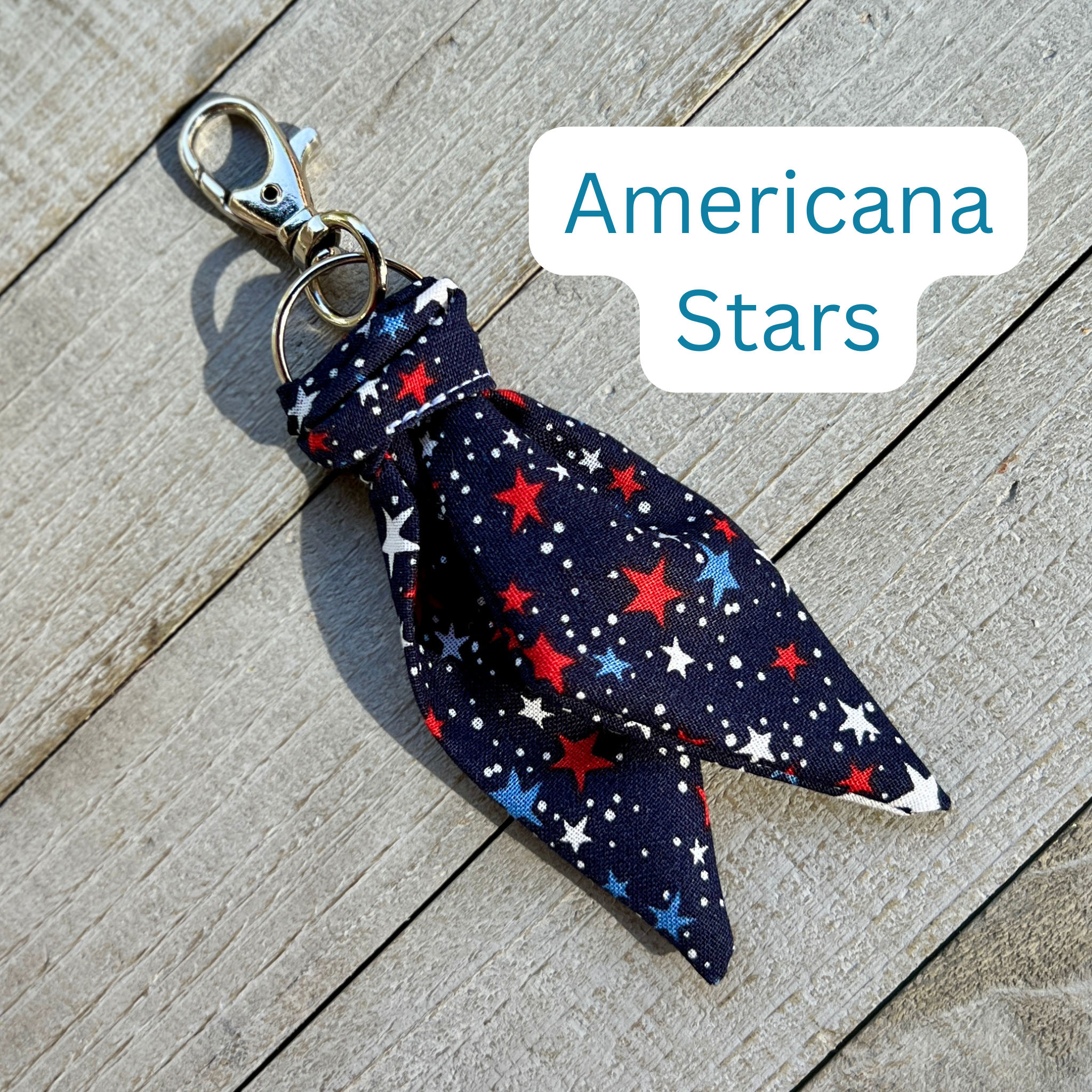 Fabric keychain with star pattern on a wooden surface, labeled 'Americana Stars'.