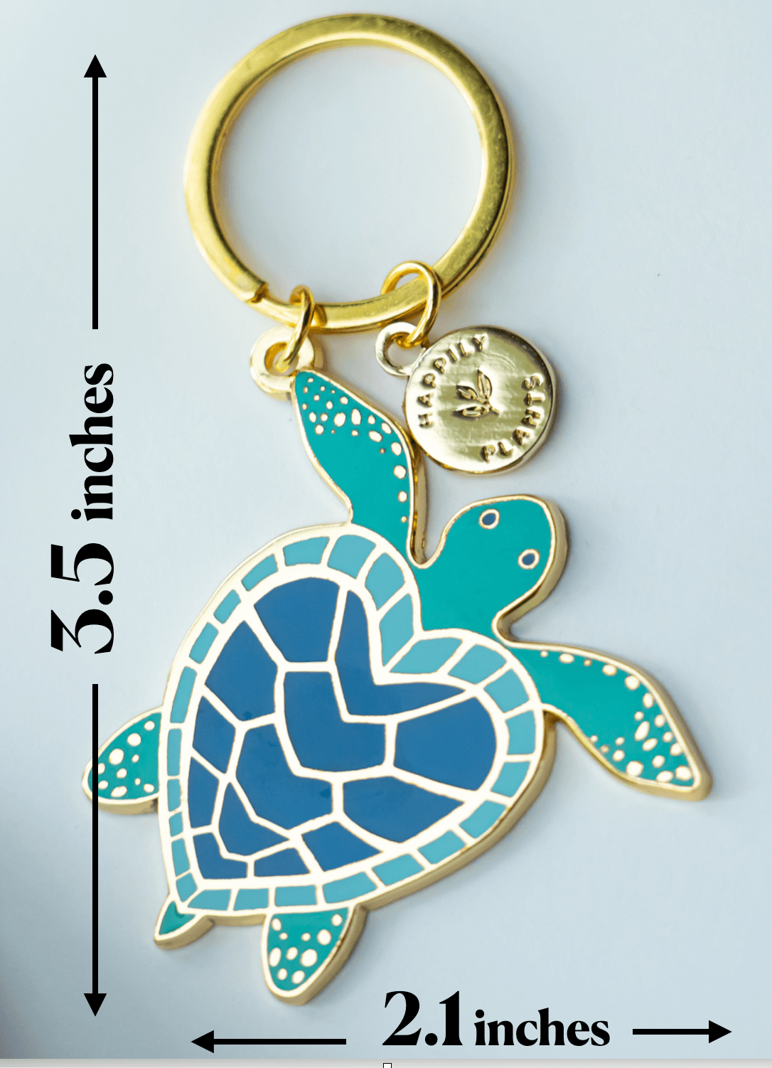 Turtle-shaped keychain with gold accents and measurement details on a light gray background