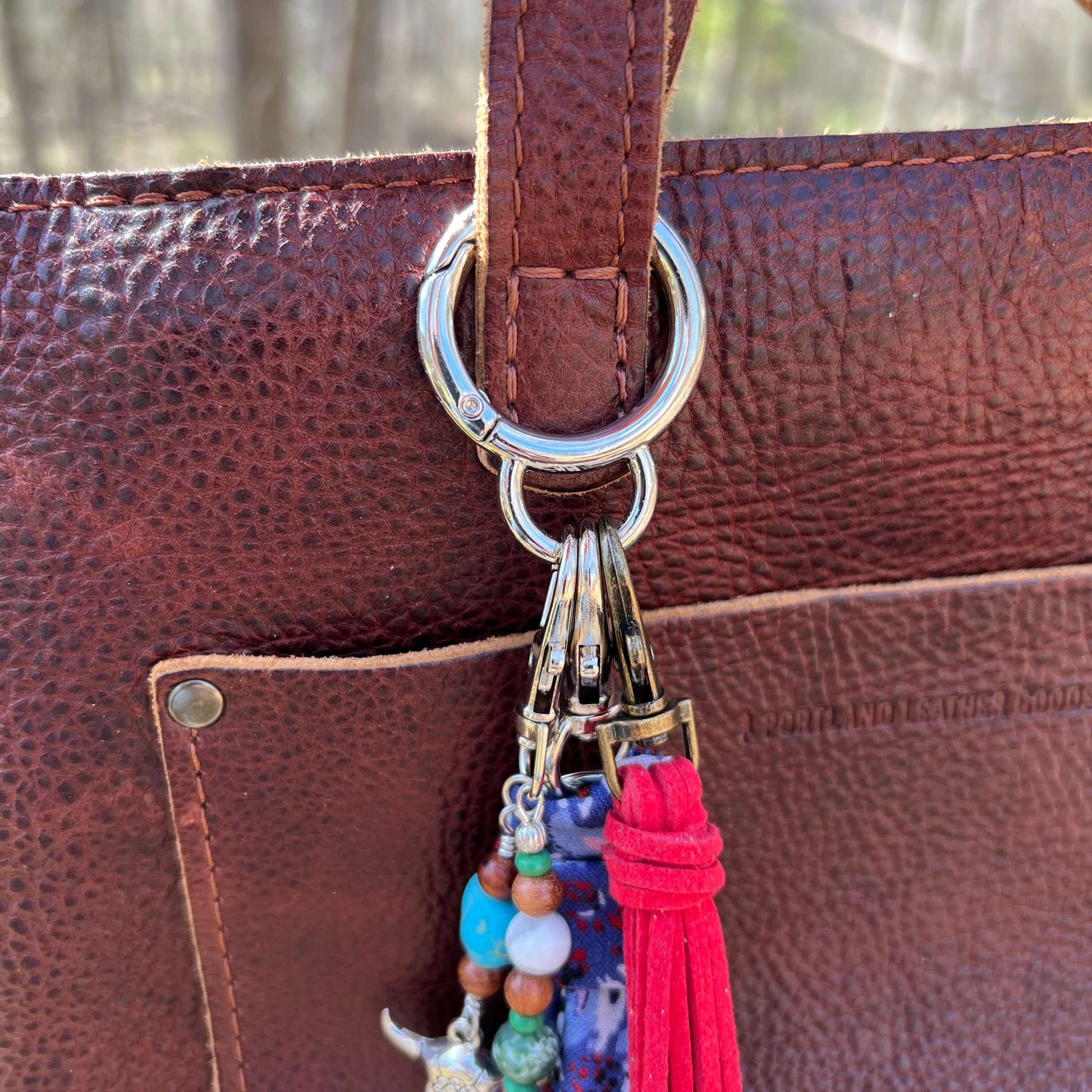spring gate bag charm holder on brown purse strap