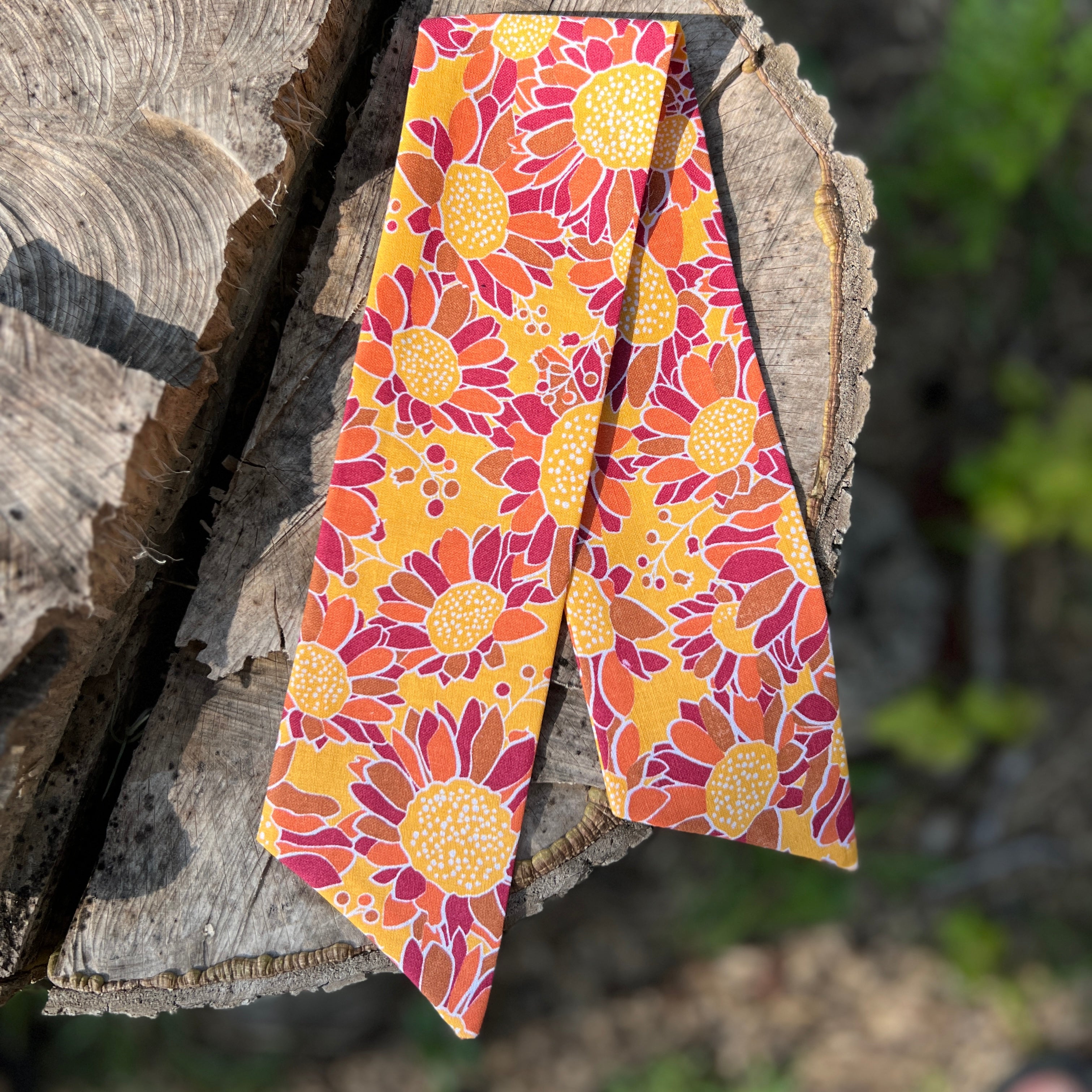 Floral-patterned tie on a wooden surface with a natural background