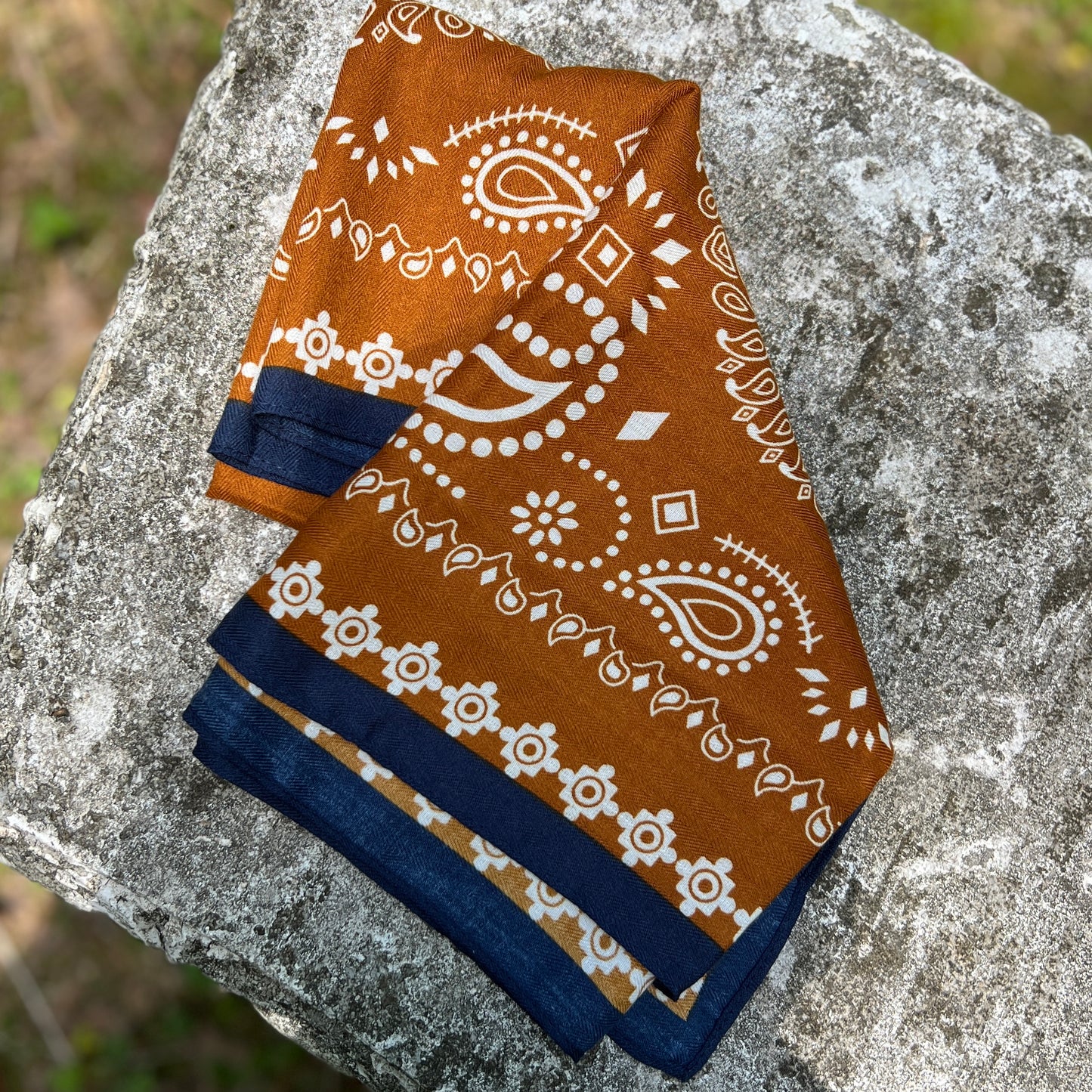 Brown bandana with white patterns on a stone surface