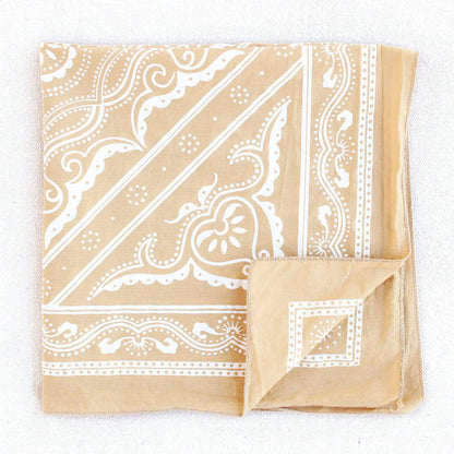 Beige bandana with white paisley pattern on a white background