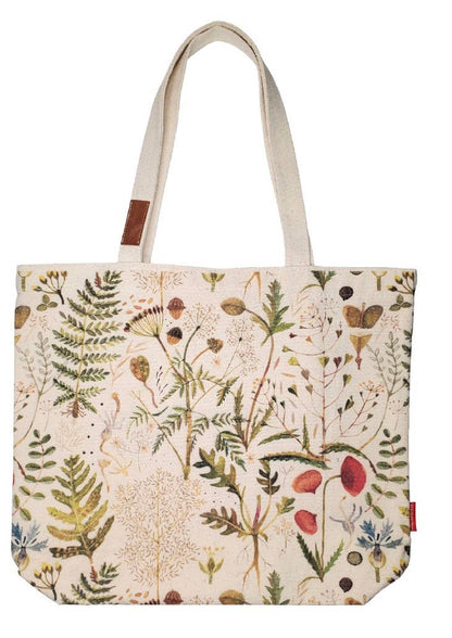 A canvas tote bag with a detailed botanical and wildflower print on a cream background, featuring natural beige shoulder straps and a small brown leather brand patch.