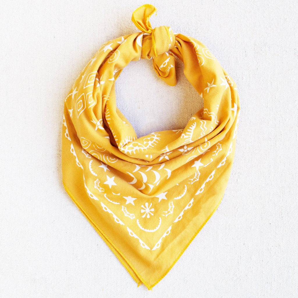 Yellow bandana with white patterns on a light gray background