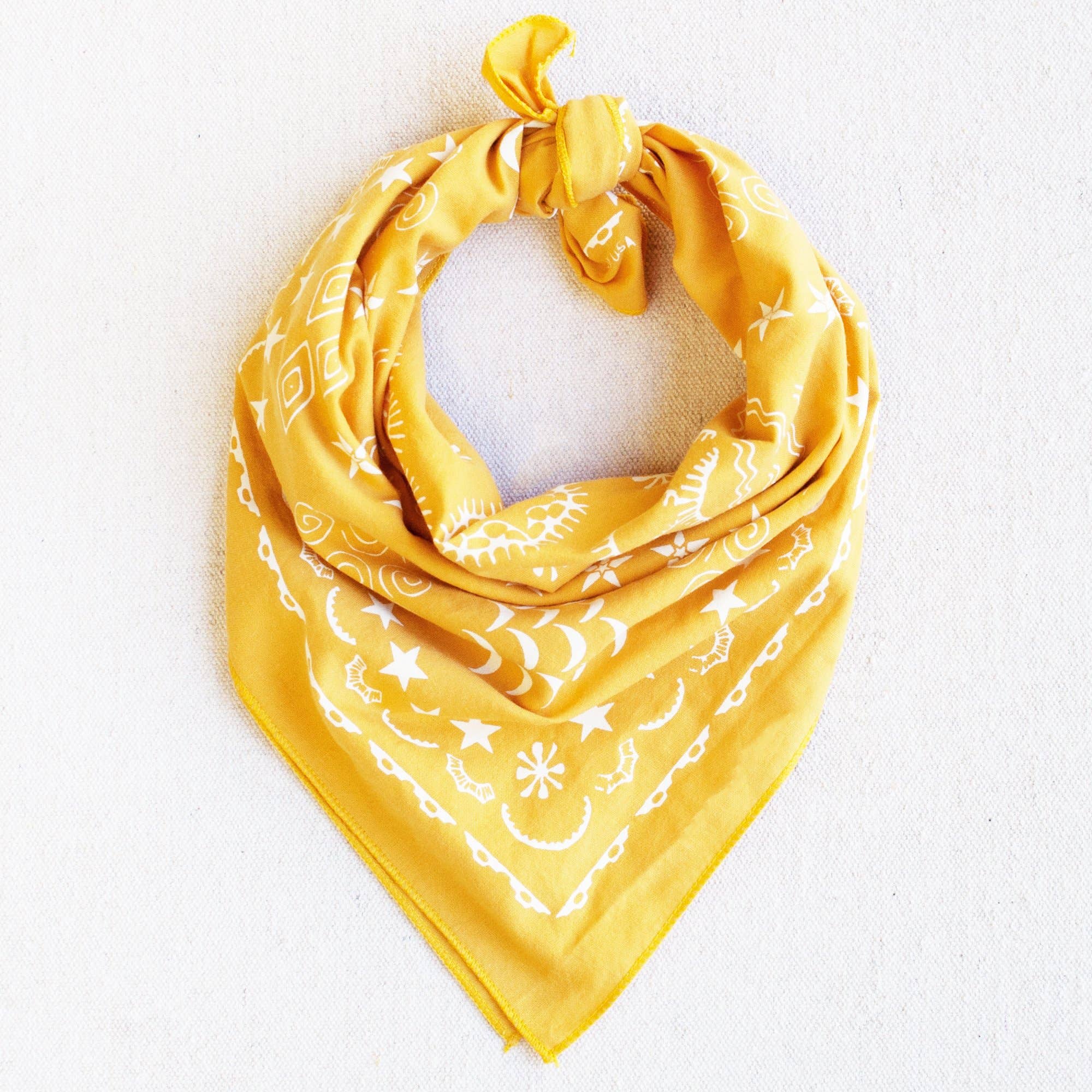 Yellow bandana with white patterns on a light gray background