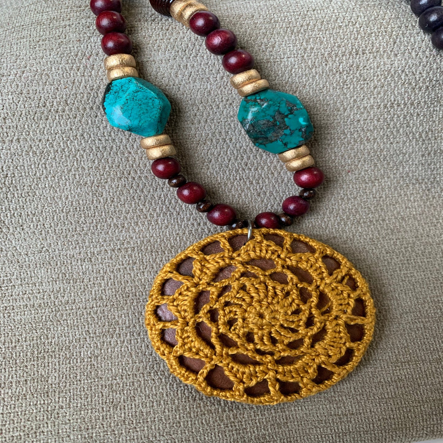 long wooden bead necklace with natural stones and gold crocheted pendant